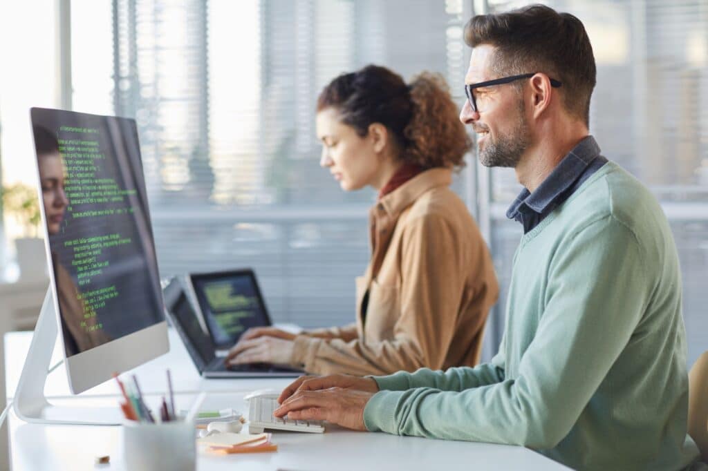duas pessoas trabalhando em frente ao computador indicando uma pesquisa sobre suporte AMS
