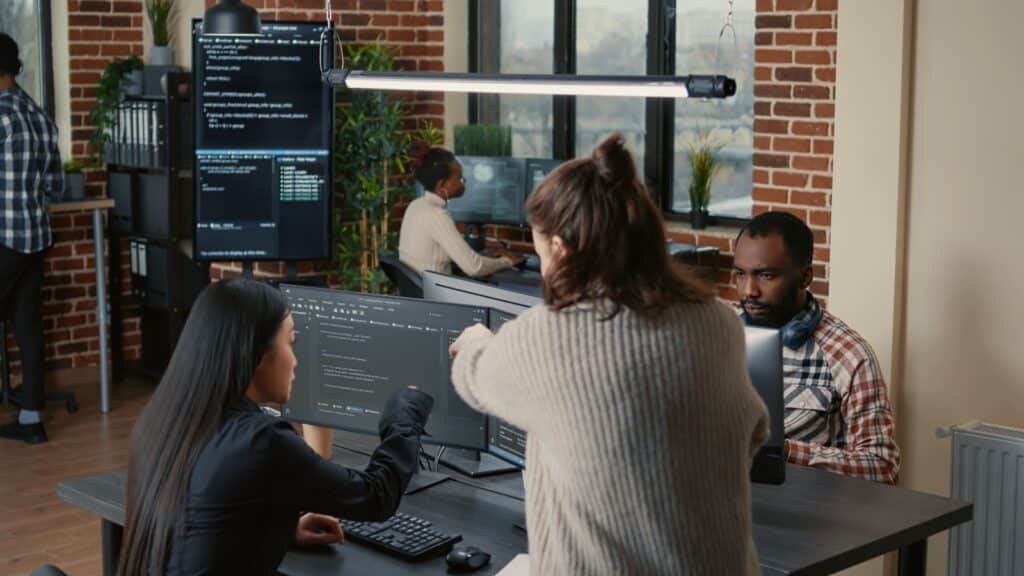 grupo de pessoas reunidas no escritório da empresa conversando sobre implementar a fábrica de software